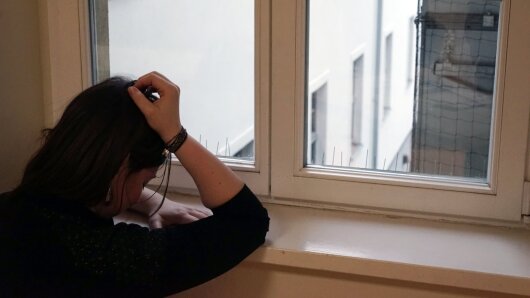 Traurige Person am Fenster