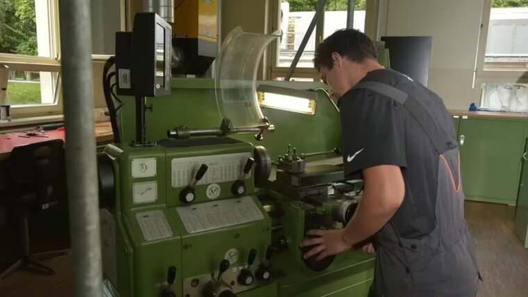 Ein Werkstattmitarbeiter an einer Maschine.