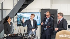 Die Forschenden Monika und Dr. Goebel informieren den Bundeskanzler Merz und Ministerpräsidenten Voigt über ihre Arbeit.