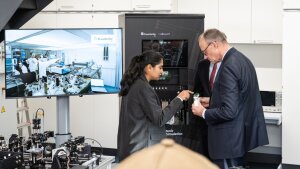 Doktorandin M. Monika erklärt Quantentechnologie dem Staatsbesuch.