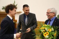 Dr. Michael Kempe von der ZEISS AG verleiht den ZEISS PhD Award an M.Sc. Johannes Stock vom Institut für Angewandte Physik für sein Promotionsvorhaben "Ganzheitliche Simulation optischer Systeme"