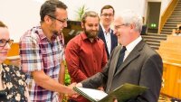 Sherzod Khujanov (links) erhält sein Masterzeugnis aus den Händen des Studiendekans.