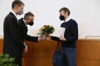Dr. Hendrik Bartko from Rohde & Schwarz Munich (left) and Prof.Dr. Christian Spielmann awrd the faculty prize for the best doctoral thesis 2021  to Dr. Richard Hollinger.
