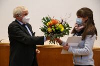 The Chair of the Committee for Education of Teachers of the FSU, Prof. Dr. Perkams, awards the exam prize for the best teachers exam of the FSU in 2021 to Elisa Helbig.  . .