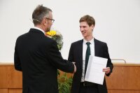 Vom Dekan, Prof. Christian Spielmann, gibt es Blumen für den Fakultäspreisträger für die beste Promotion 2022 Dr.-Ing. Robert Wonneberger (rechts).