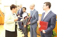 Dr. Angela Unkroth übergibt den Absolventen ein Erinnerungsbuch.