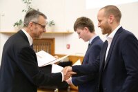 Der Dekan überreicht die Promotionsurkunden.
