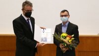 Der Dekan Prof. Dr. Christian Spielmann verleiht den Examenspreis der FSU 2021 an M.Sc. Julian Picker.