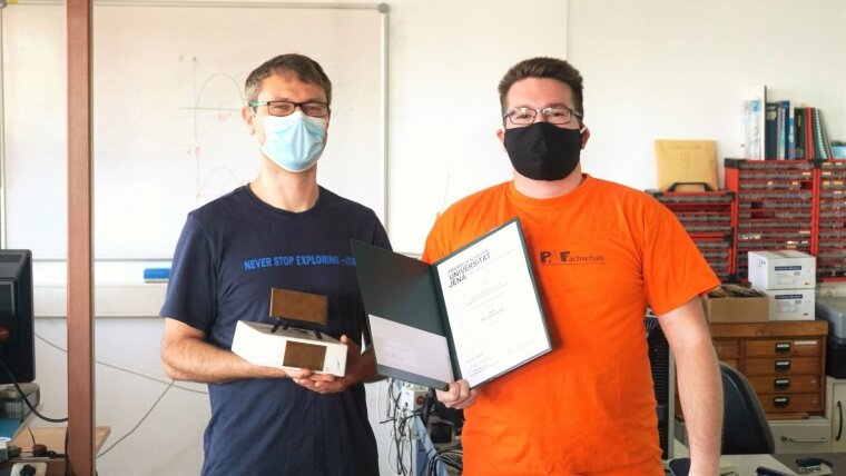 PD Dr. Roman Forker erhält den Lehrpreis vom Fachschaftsratsvorsitzenden Georg Schwartz.