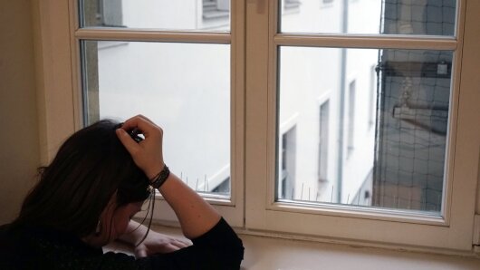 Traurige Person am Fenster